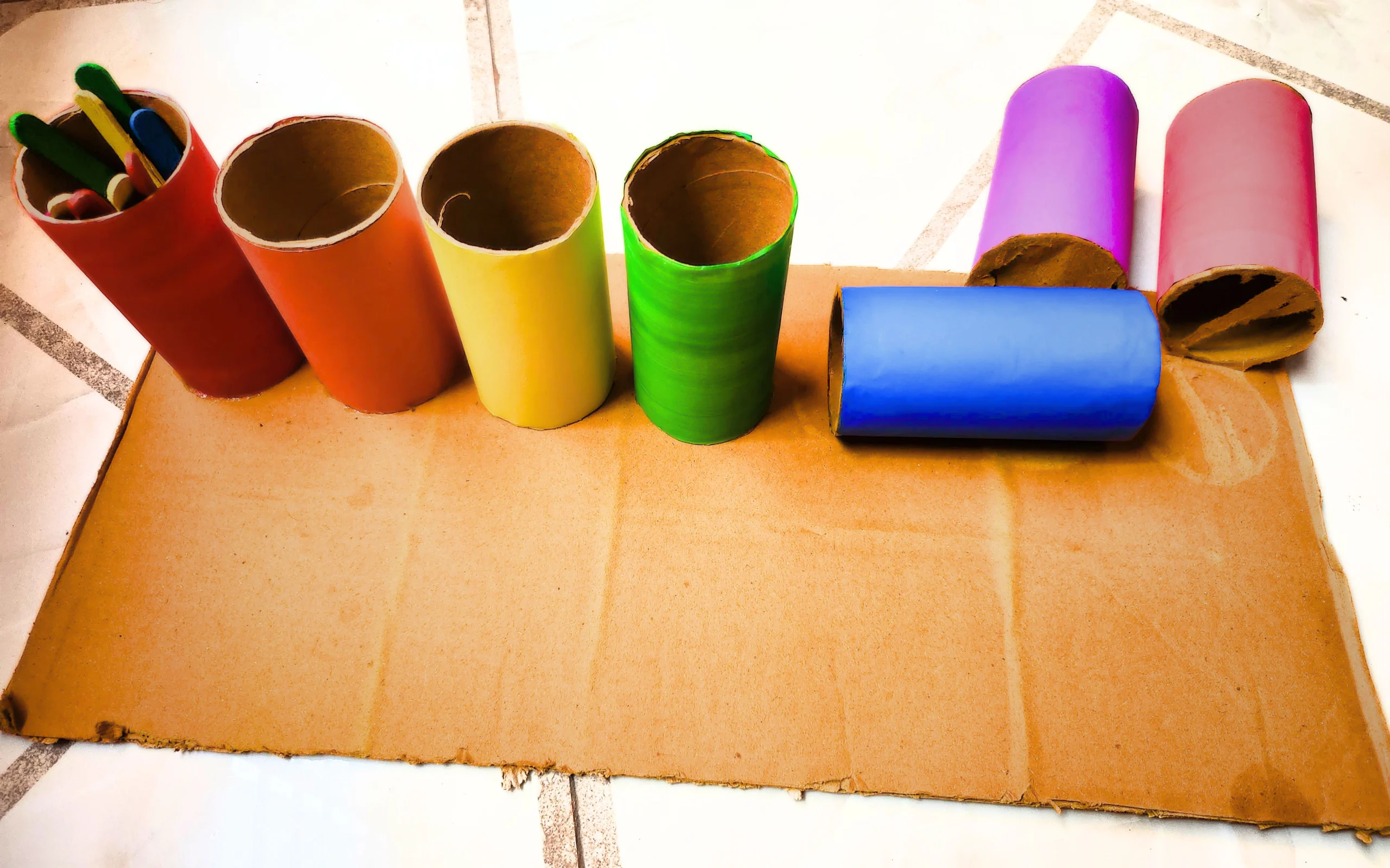 three colored toilet paper rolls have been pulled out of the DIY color sorting tray