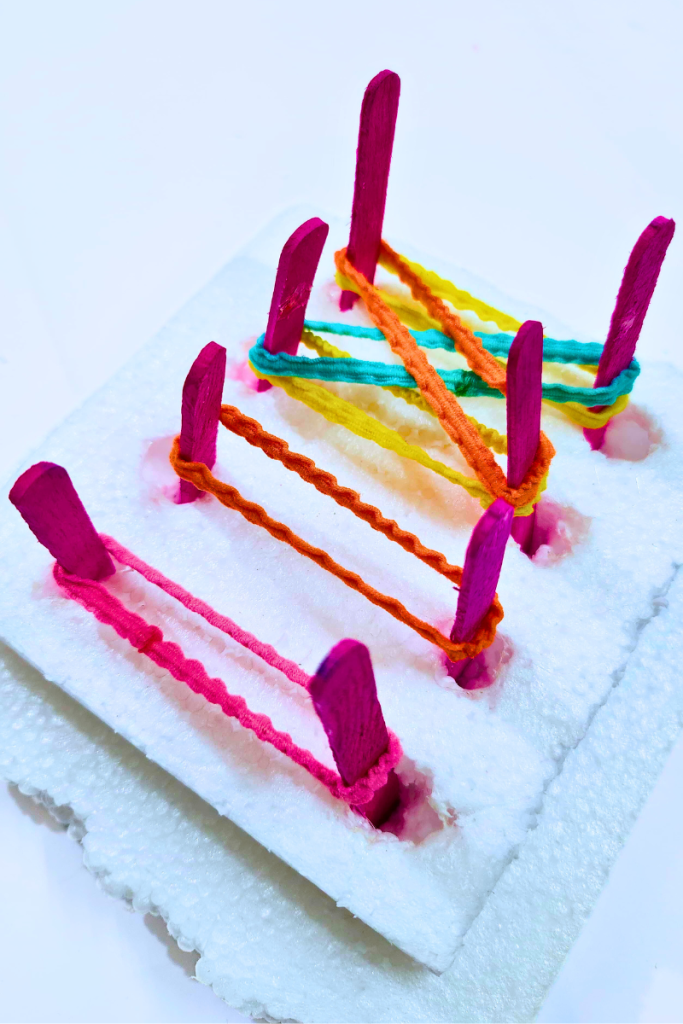 DIY geoboard with styrofoam base and popsicle pegs